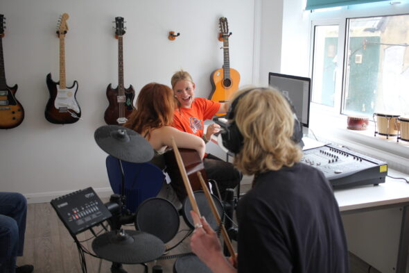 Young people playing instruments in our day centre's activities room